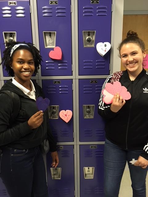 (Lto R) Hailey Roseboro (Dance, 11th) and Ruby Long (Creative Writing, 10th) fastening heartfelt messages to main hallway lockers.