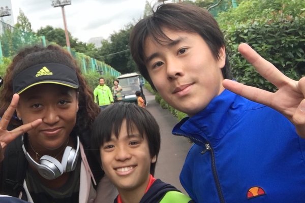 Naomi Osaka posing with two young admirers in Ariake Tennis Forest Park in Tokyo in 2017