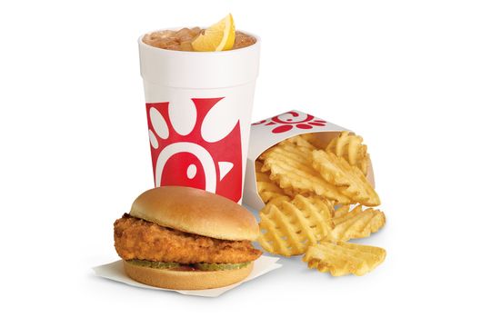 A Chick-fil-A sandwich with waffle fried and iced tea. 