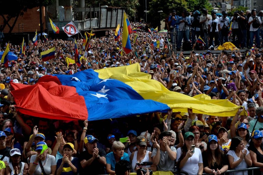 Participants in a mass opposition rally against Venezuelan leader Nicolás Maduro on Wednesday in Caracas listen to National Assembly head Juan Guaidó, who declared himself the rightful president of Venezuela.