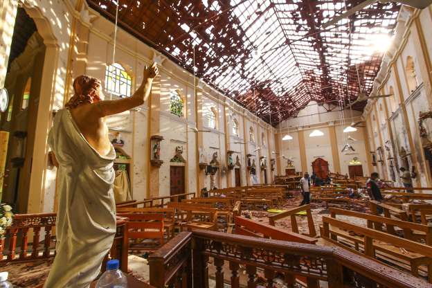 Officials investigate the damage in St. Sebastians Church caused by one of six suicide bombings in Sri Lanka on Easter.