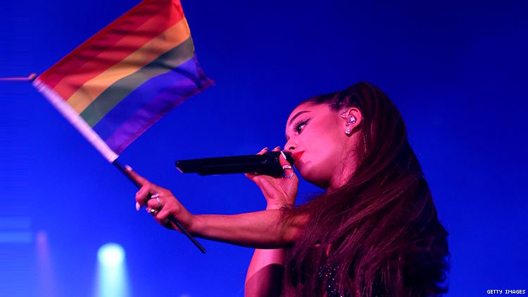 Ariana Grande waving rainbow flag during performance.