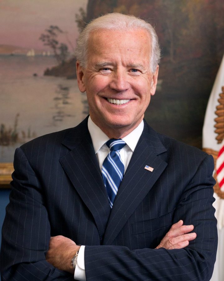 President Joe Biden standing with his arms crossed.