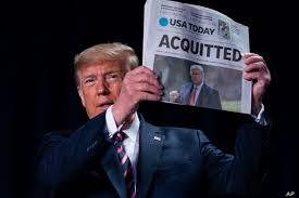 Trump holding a newspaper, its headlines say ACQUITTED.