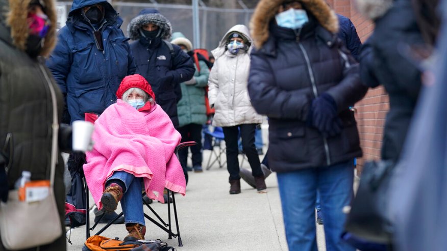 Judy McKim, center left, waits in line with others for the COVID-19 vaccine in Paterson, N.J., Thursday, Jan. 21, 2021. The first people arrived around 2:30 a.m. for the chance to be vaccinated at one of the few sites that does not require an appointment.