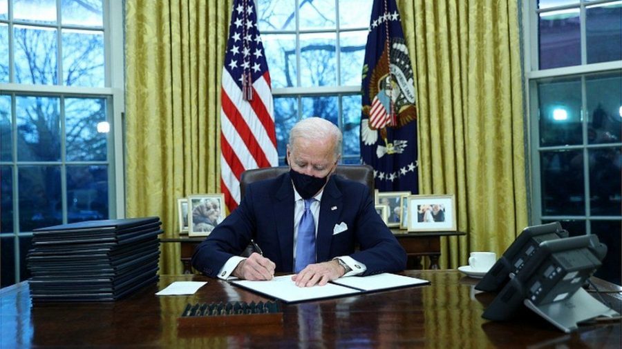 President Joe Biden signing executive orders.