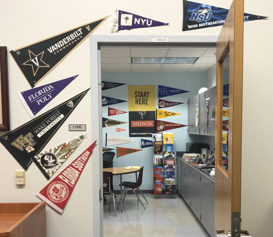 The entrance to Ms. Gill's office with several college flags around the doorway. 