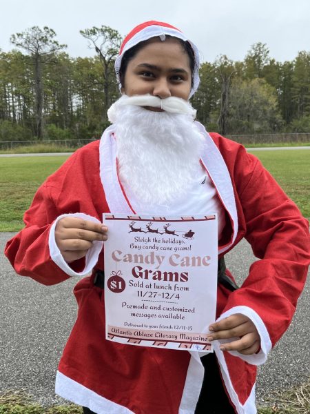 Alyssa Danish posing as Santa Clause in order to promote Atlantis Ablazes Candy Cane Grams.