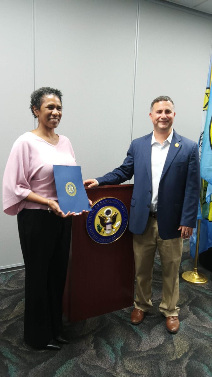 Congressman Darren Soto presents certificate to Ms. Brunson at the Kissimmee Civics Center.