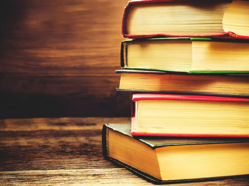 Stack of books on the dark wood background.