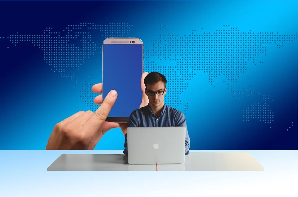 Image of a man surfing the internet on a computer and phone.